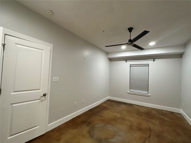 Bedroom 1. Unfurnished room featuring scorned concrete flooring, a ceiling fan, and recessed LED lighting | Image 7