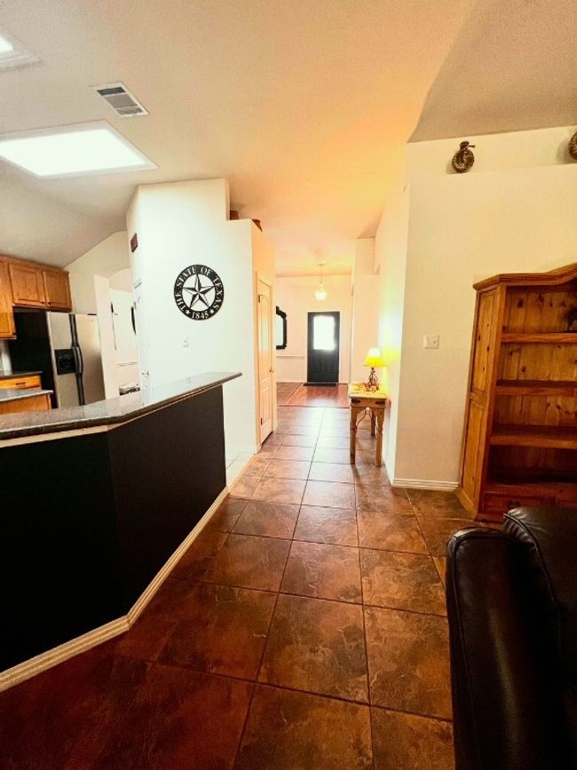 Hallway featuring lofted ceiling and dark tile patterned floors | Image 7