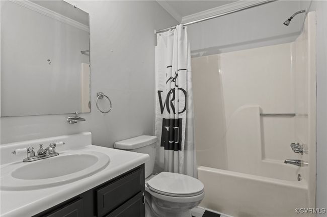 Bathroom featuring shower / bathtub combination with curtain, crown molding, vanity, and toilet | Image 17