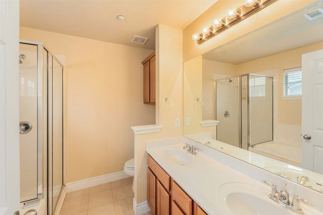 Full bath with a shower stall, double vanity, a garden tub, and tile patterned floors | Image 16