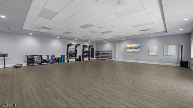 Miscellaneous room with a tray ceiling, wood finished floors, baseboards, and visible vents | Image 45