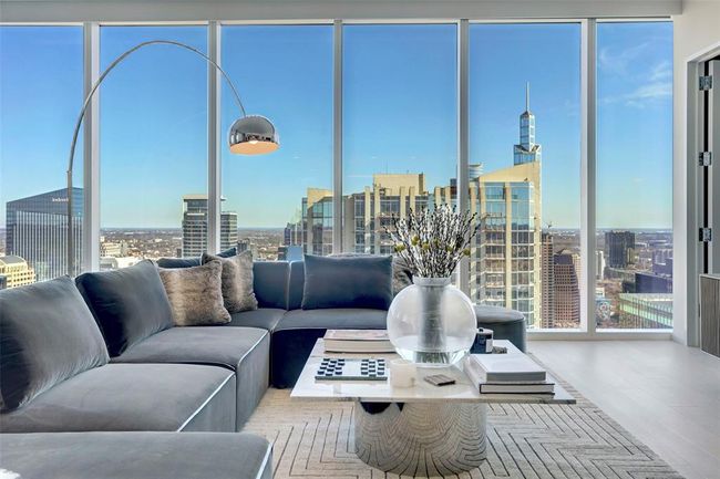 Living room with a city view, healthy amount of natural light, a wall of windows, and wood finished floors | Image 4