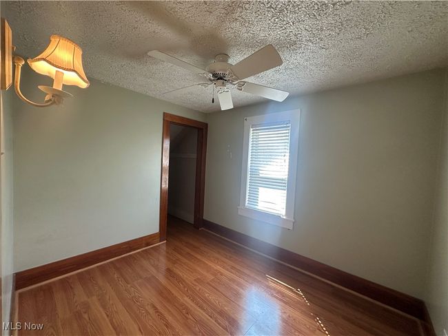 Spare room featuring baseboards, wood finished floors, a textured ceiling, and ceiling fan | Image 16