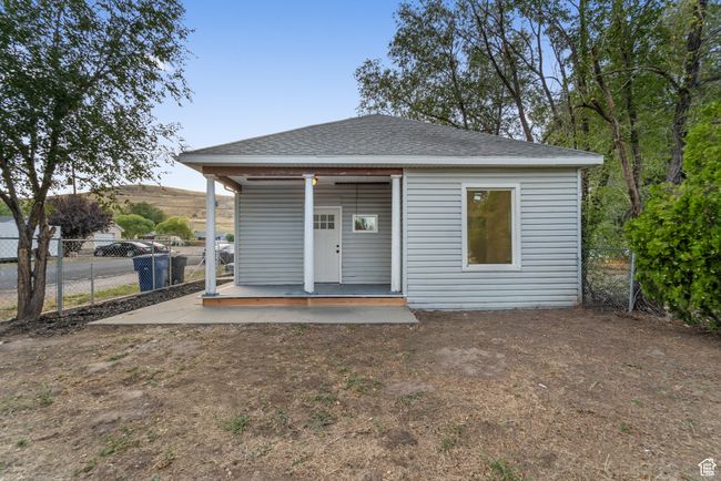 Exterior space featuring a shingled roof, a porch, and fence | Image 23