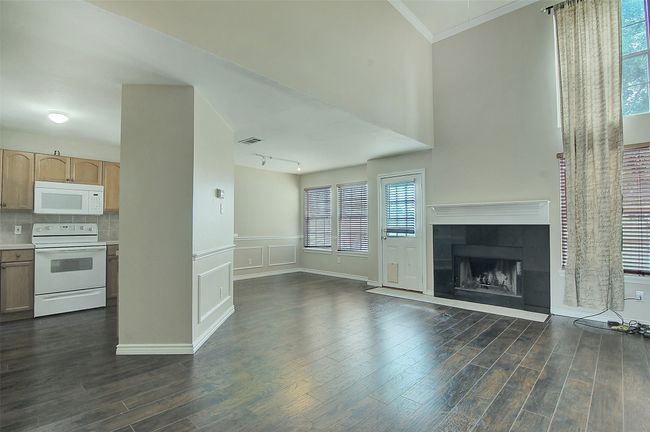 Unfurnished living room featuring a tile fireplace, dark wood-type flooring, and ornamental molding | Image 7