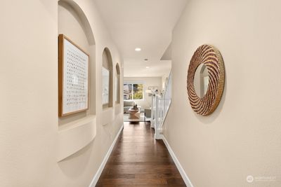 Hall with art alcoves leads you to main living area. | Image 3