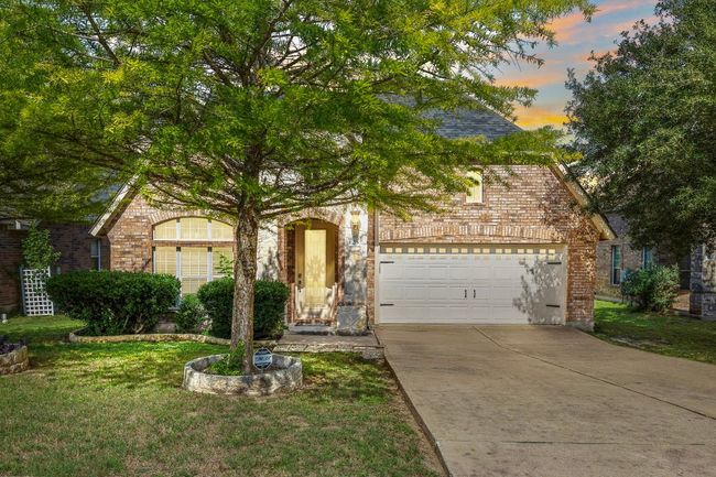 View of front facade featuring brick siding, concrete driveway, and a lawn | Image 36