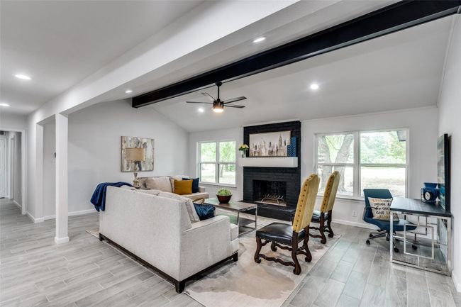 Living area with a ceiling fan, wood finish floors, recessed lighting, and a brick fireplace | Image 10