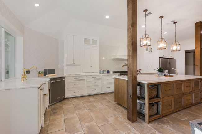 Kitchen featuring stainless steel appliances, custom exhaust hood, light countertops, white cabinets, and glass insert cabinets | Image 14