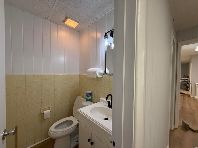 Half bath featuring wood finished floors, vanity, and tile walls | Image 10