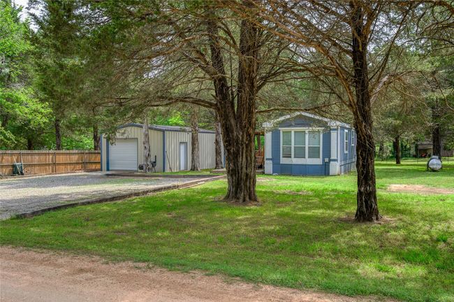 View of front of house with an outdoor structure, driveway, and a detached garage | Image 15