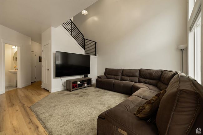 Living room featuring light wood finished floors, baseboards, and a towering ceiling | Image 13