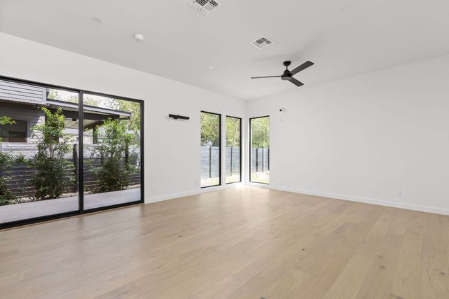 Empty room with light wood-style floors and ceiling fan | Image 13