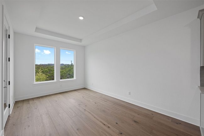 Empty room featuring a tray ceiling, hardwood / wood-style floors, baseboards, and recessed lighting | Image 11