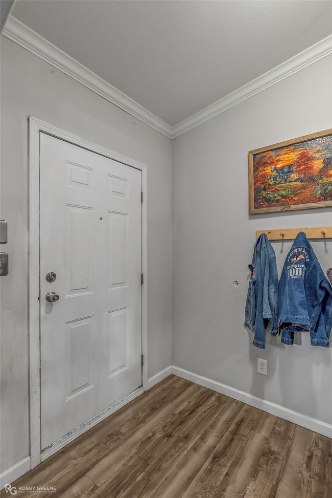 Entryway with ornamental molding, wood finished floors, and baseboards | Image 7