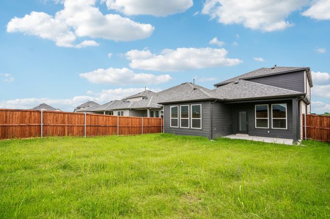 Rear view of house with a patio and a shingled roof | Image 15