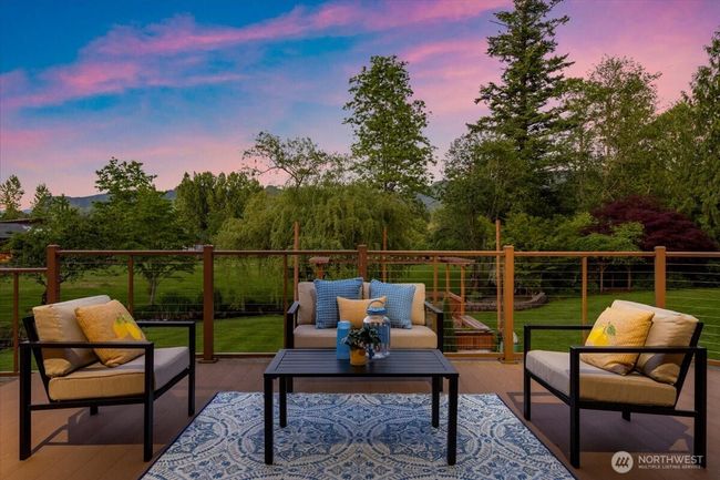 Spacious deck perfect for entertaining, unwinding, and taking in the peaceful natural surroundings. Lower-level rec room with wet bar and cozy fireplace—perfect for entertaining. | Image 26