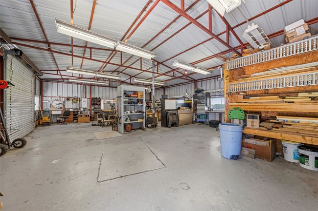 Garage featuring a workshop area and metal wall | Image 32