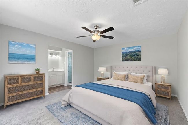 The spacious primary suite is a peaceful retreat, featuring large windows that fill the room with natural light. Its en-suite bathroom offers comfort and convenience. | Image 16