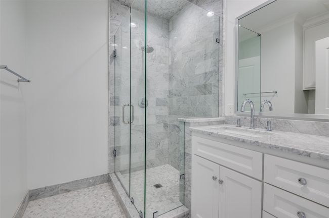 Full bathroom featuring vanity, a marble finish shower, and baseboards | Image 19