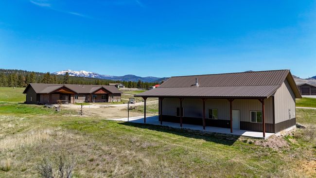 Back of house with metal roof, a mountain view, and a yard | Image 26