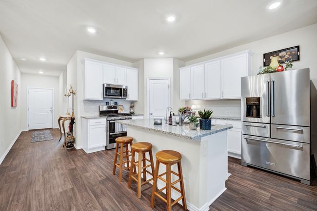 Kitchen with white cabinetry, appliances with stainless steel finishes, and dark wood-style floors | Image 7