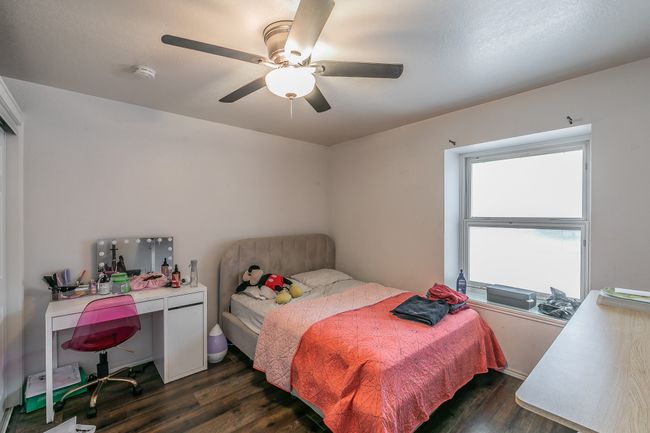 Unit 4900 Second Bedroom featuring ceiling fan and dark hardwood / wood-style floors | Image 19