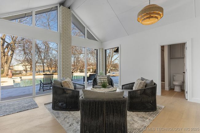Sun room with vaulted ceilings and a bathroom that leads to the pool | Image 31