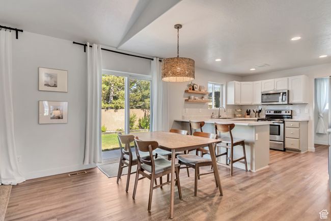 Dining room with recessed lighting, light wood finished floors, and a barn door | Image 7