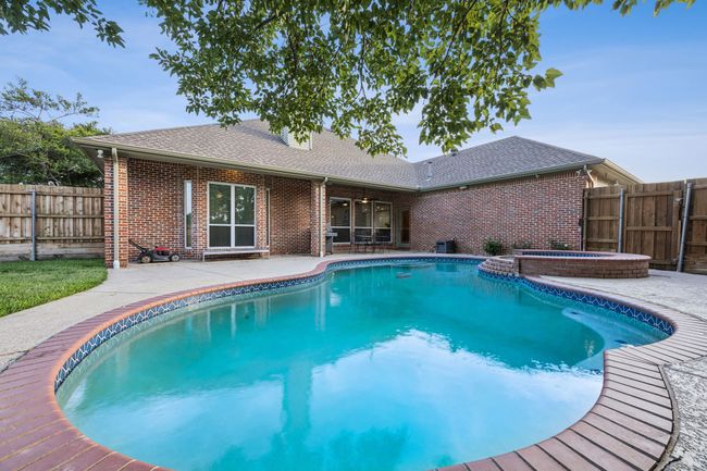 View of swimming pool with a patio area, a fenced backyard, and a pool with connected hot tub | Image 27