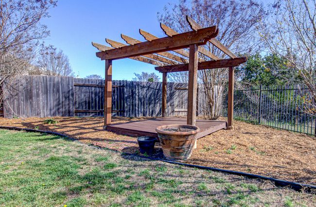 View of yard featuring a wooden deck, a pergola, and a fenced backyard | Image 32
