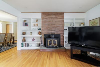 Bookcases surround fireplace with wood stove insert | Image 3