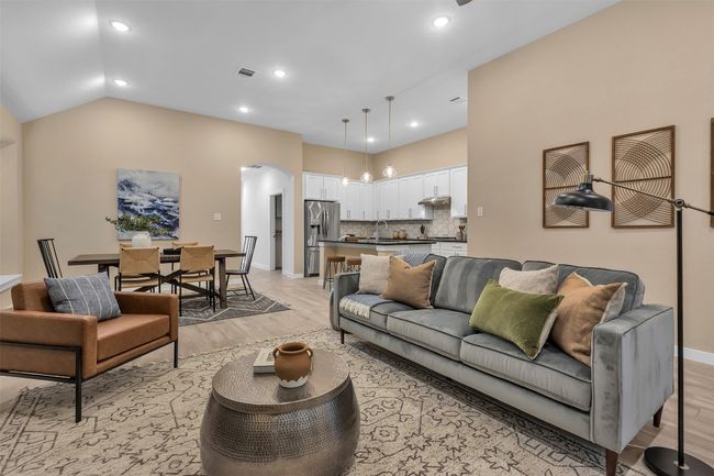 Living area featuring light wood-type flooring, vaulted ceiling, arched walkways, and recessed lighting | Image 14