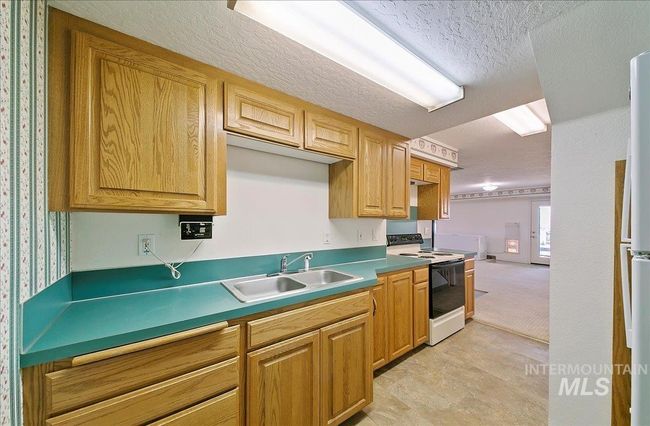 Kitchen featuring range with electric cooktop and a textured ceiling | Image 23