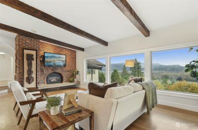 A cozy fireplace, brick accents and custom carved beams provide a stunning complement to a breathtaking view. | Image 3