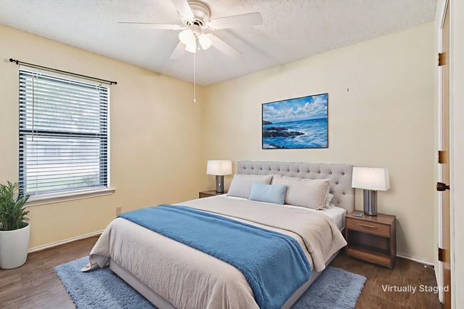 Bedroom with wood finished floors, a textured ceiling, and ceiling fan | Image 25