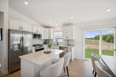 (Photo of a decorated model, actual homes finishes will vary) Enjoy plenty of seating at the kitchen island and dining area adjacent to the kitchen. Perfect for entertaining or having a family meal together. | Image 3