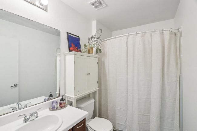 Full bathroom featuring vanity, toilet, curtained shower, and visible vents | Image 17