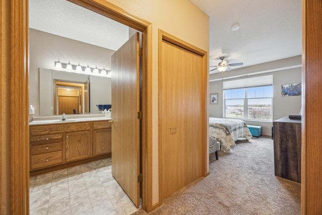 A second closet with-in the ensuite offers additional storage. There is natural wood stain woodwork throughout this condo. | Image 15