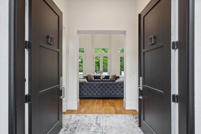 Step into elegance at 22 East Shade Lane, Houston, through grand double doors, revealing a sophisticated living area. | Image 6