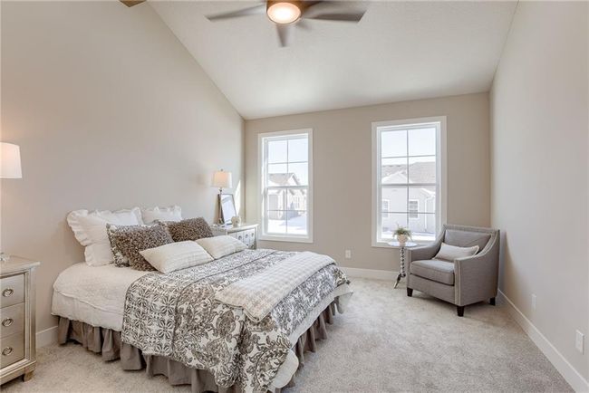Bedroom with light carpet, baseboards, vaulted ceiling, and a ceiling fan | Image 16