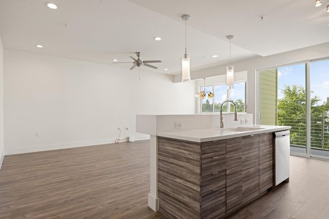 Kitchen with plenty of natural light, recessed lighting, dark wood-style floors, and a kitchen island with sink | Image 4