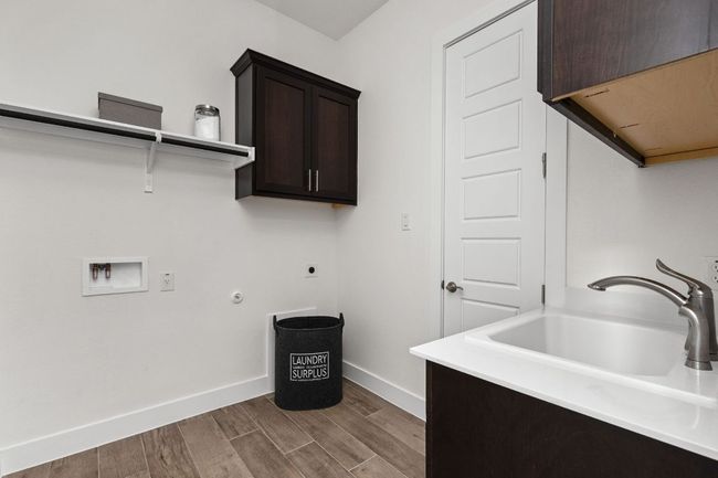 Washroom featuring cabinet space, dark wood-style floors, electric dryer hookup, baseboards, and hookup for a washing machine | Image 24