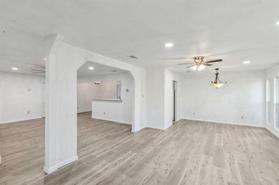 Unfurnished living room with light wood-type flooring and ceiling fan | Image 2