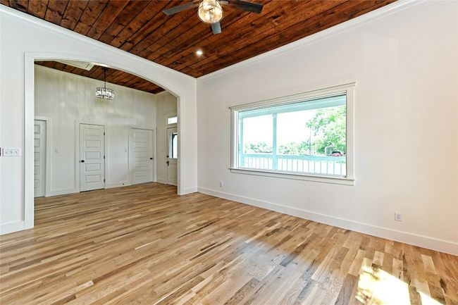 Living Room with wood ceiling, a ceiling fan, light wood-style flooring, arched walkways, and ornamental molding | Image 12