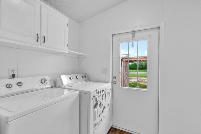 Washroom with washer and dryer, cabinet space, and a textured ceiling | Image 18