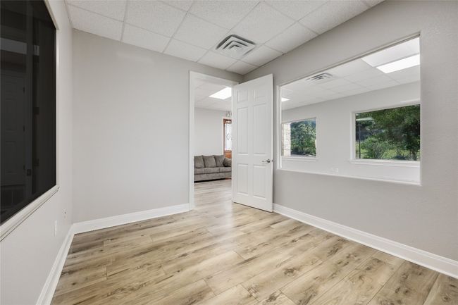 Unfurnished room featuring wood finished floors, a paneled ceiling, and visible vents | Image 25