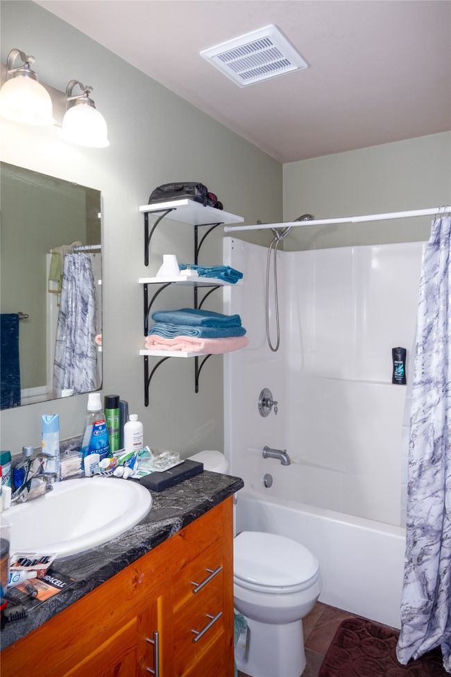 Full bathroom featuring visible vents, toilet, shower / bathtub combination with curtain, vanity, and tile patterned flooring | Image 49
