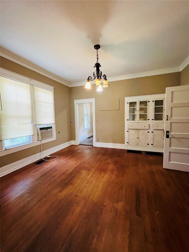 Unfurnished dining area with a chandelier, cooling unit, crown molding, and dark wood-type flooring | Image 25
