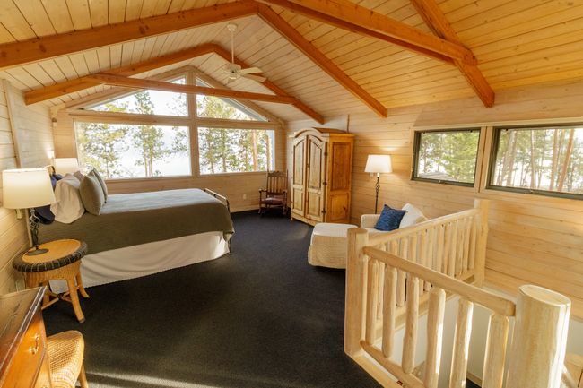 Bedroom with carpet floors, vaulted ceiling with beams, wood ceiling, and wood walls | Image 38